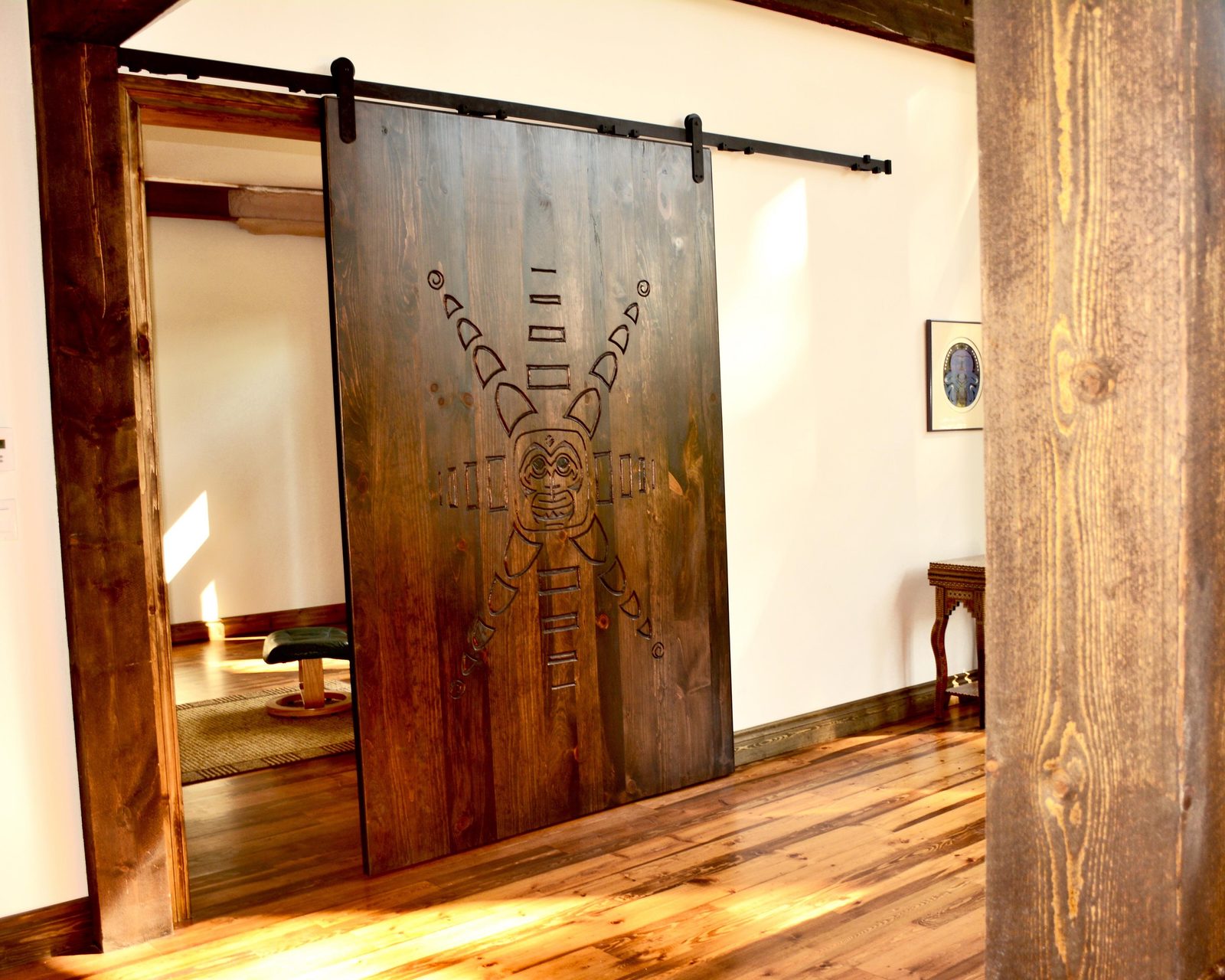 Custom carved barn door on Mikron commercial-grade 125 lb barn door track hardware